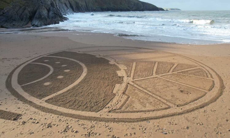 The Agri Trader logo drawn in the sand